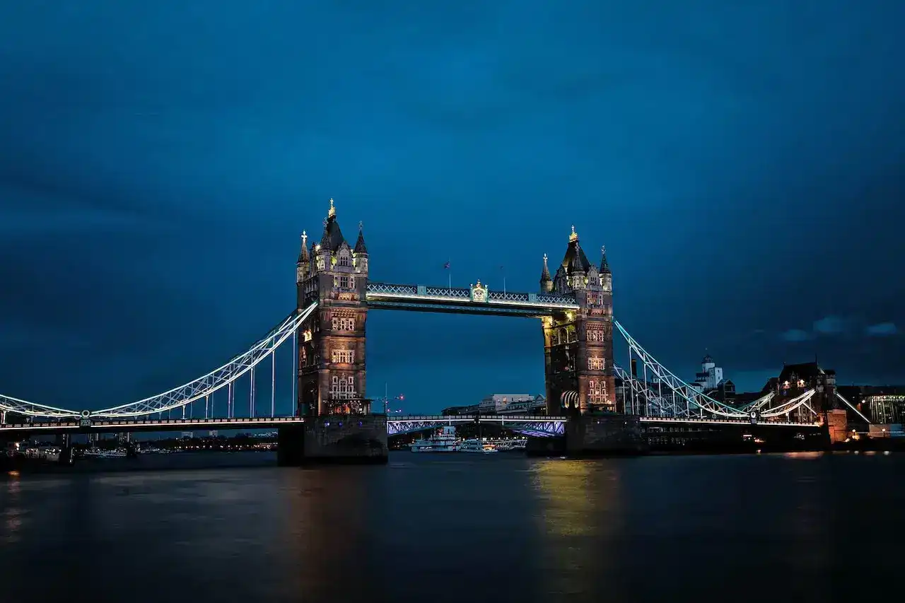Tower Bridge in London illuminated at night over River Thames.