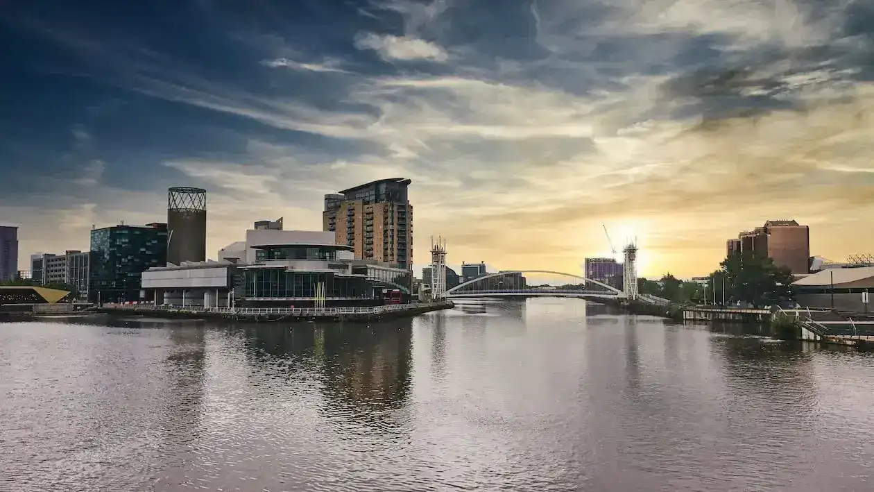 Modern buildings and bridge at Salford Quays during sunset.
