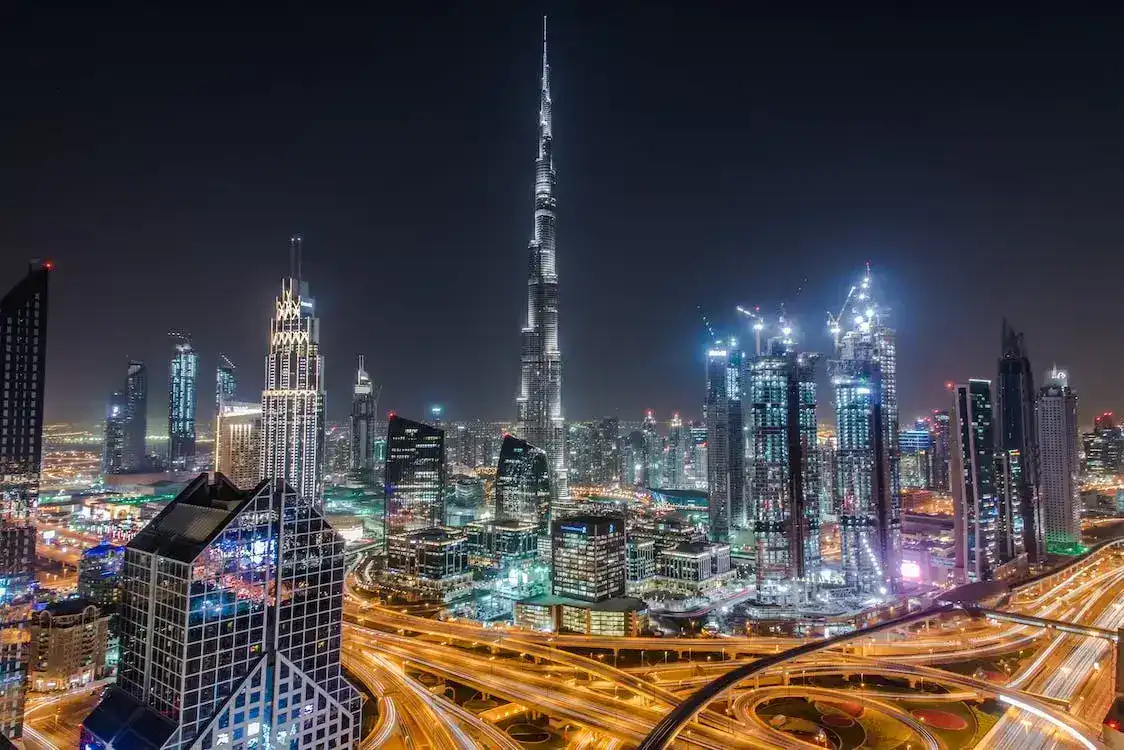 Illuminated Dubai skyline featuring the Burj Khalifa at night.