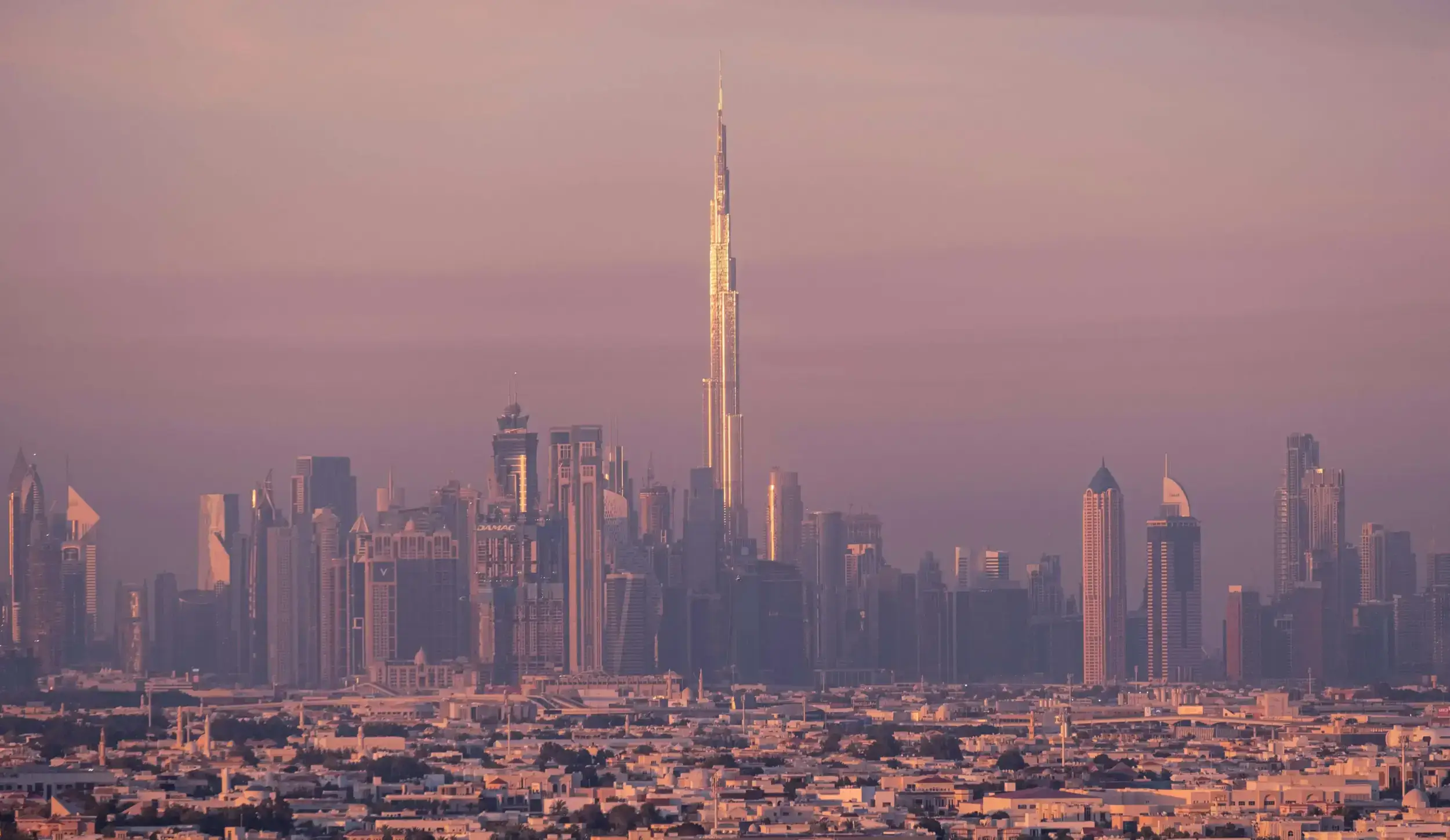 Dubai skyline featuring the Burj Khalifa at sunset.