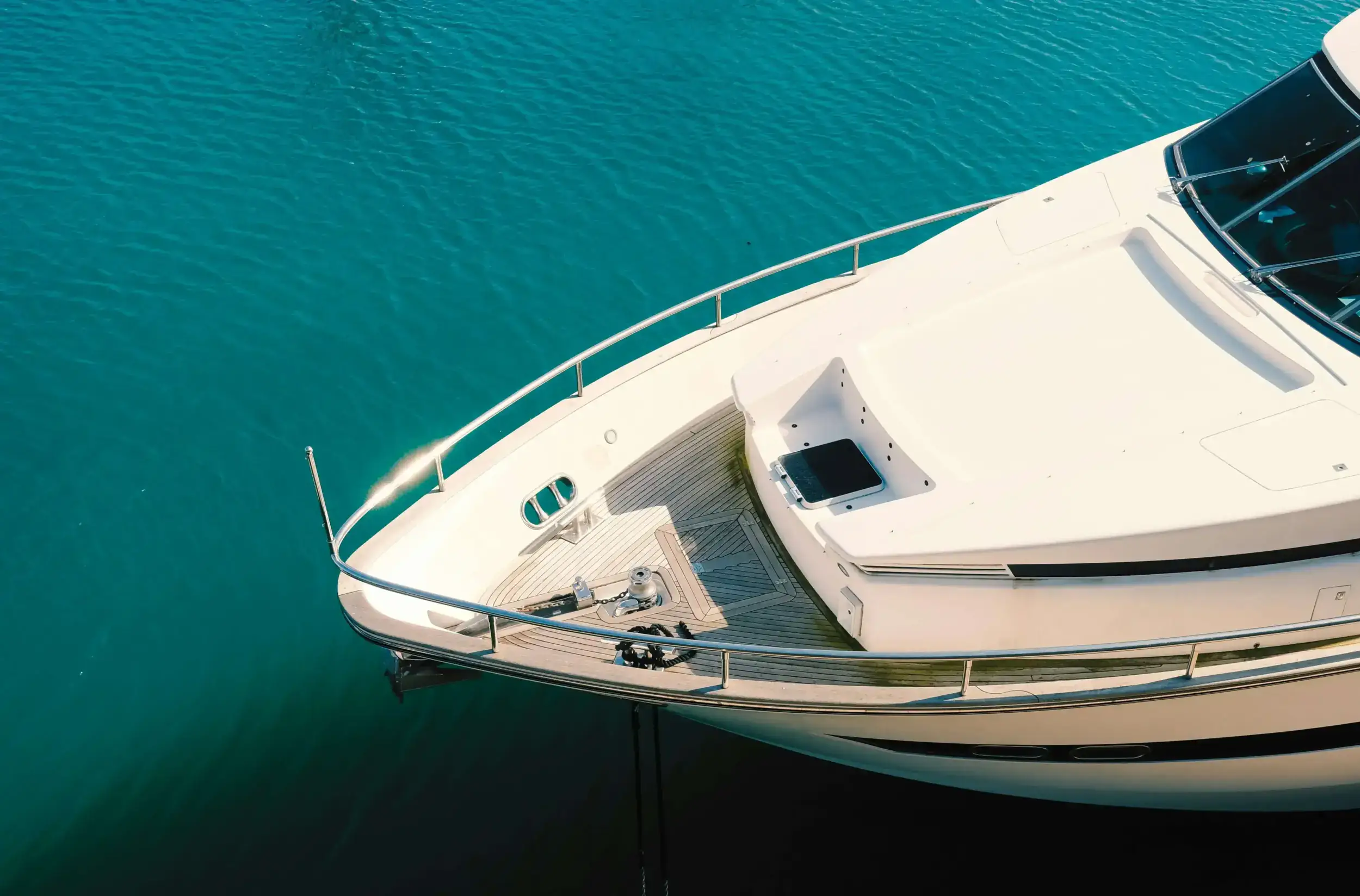High-angle view of a white yacht on turquoise water.