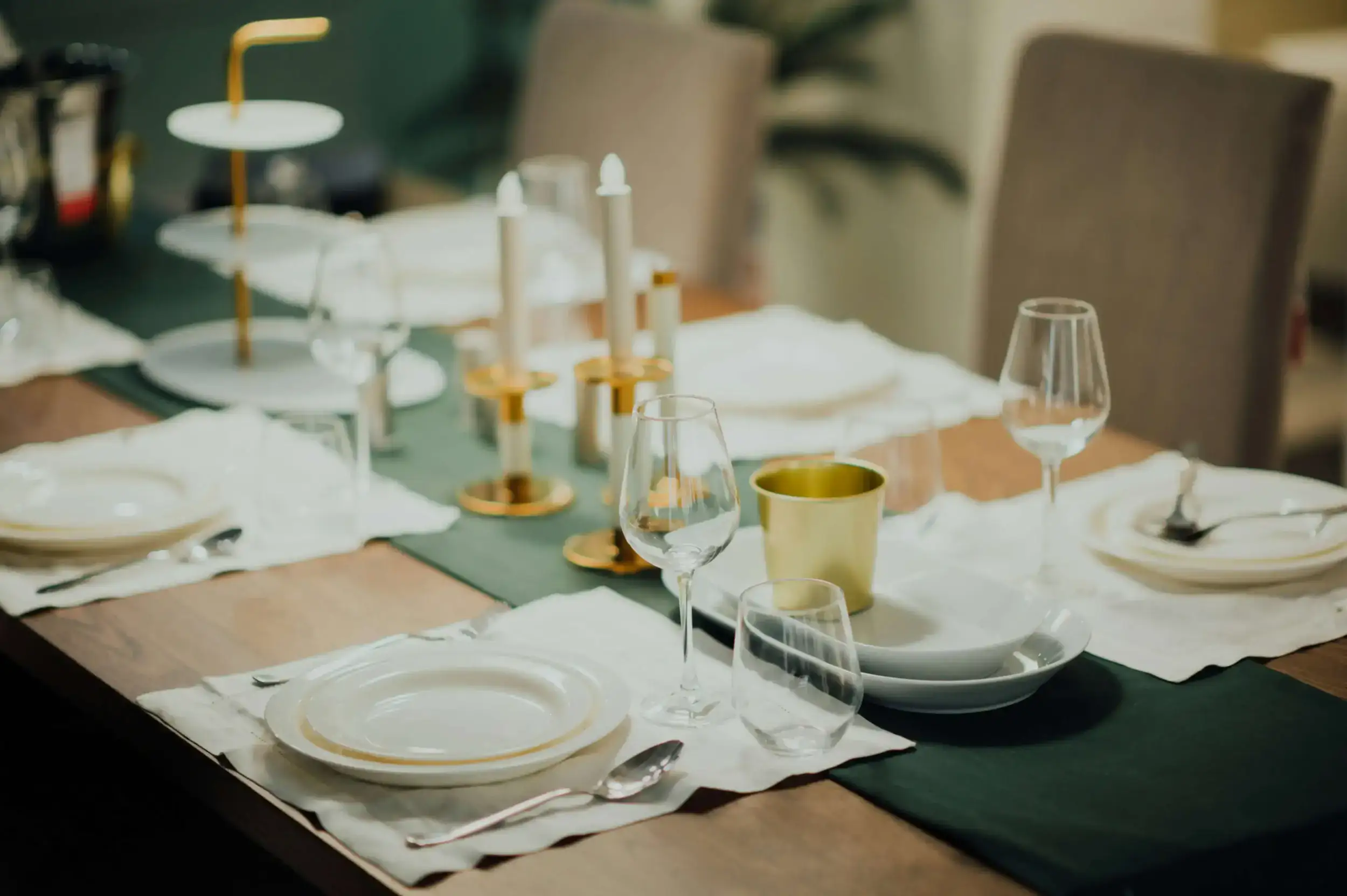 Elegant dining table setting with white plates and gold accents.