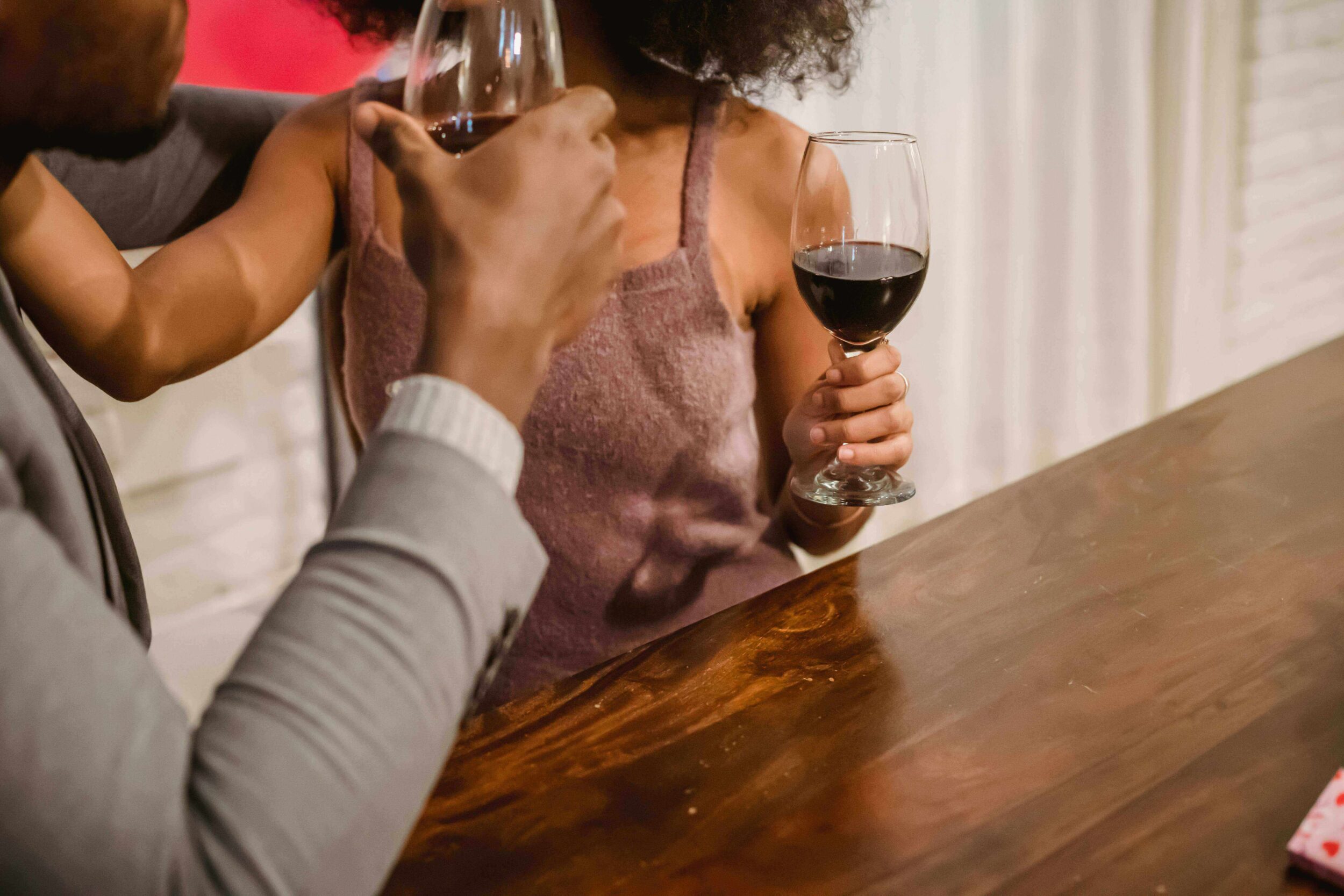 A couple toasts with glasses of red wine.