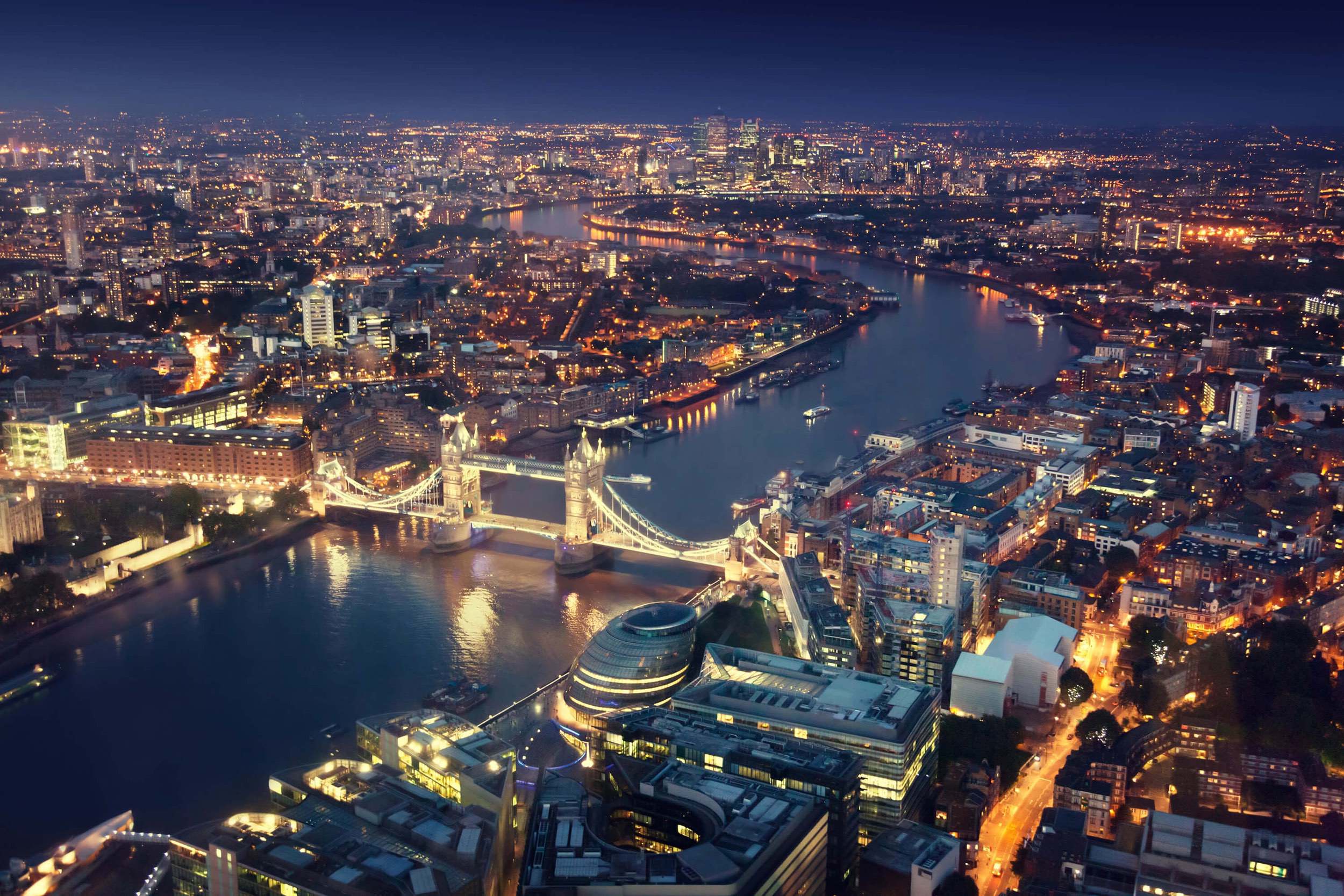 Illuminated Tower Bridge and London city skyline at night
